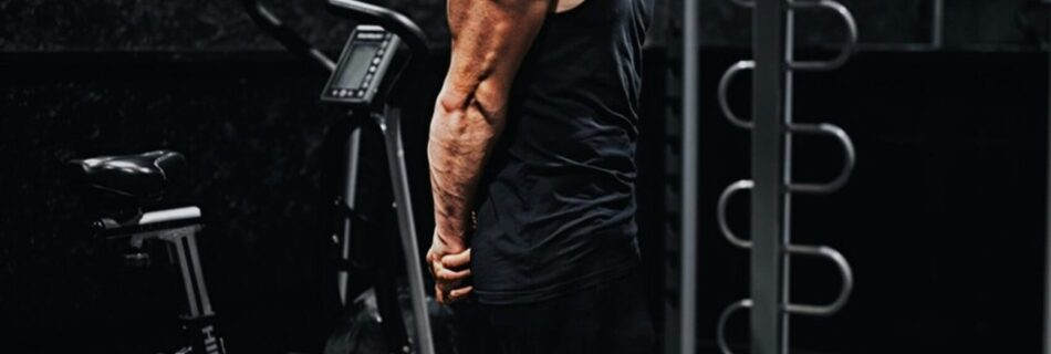 man in black tank top and black pants standing on black exercise equipment